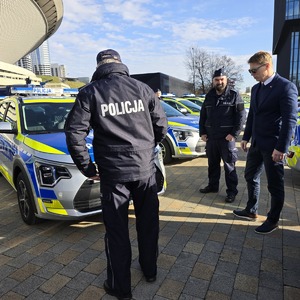 zdjęcie przedstawia komendanta i prezydenta podczas przekazania radiowozów