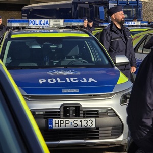 zdjęcie przedstawia policjanta przy radiowozie