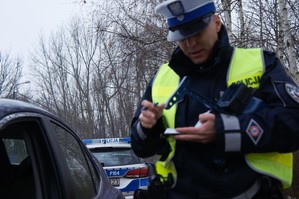 zdjęcie przedstawia policjanta podczas kontroli drogowej