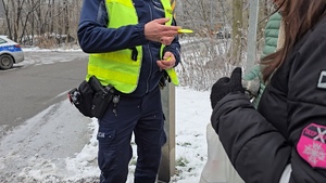zdjęcie przedstawia policjanta rozdającego odblaski