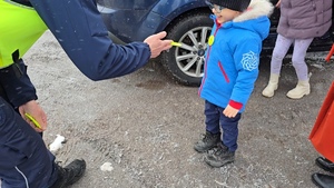 zdjęcie przedstawia policjanta rozdającego odblaski