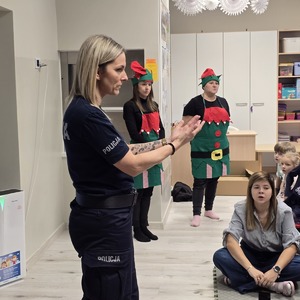 zdjęcie przedstawia policjantkę rozmawiającą z dziećmi