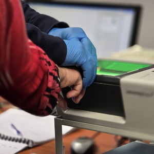 zdjęcie przedstawia policjanta wykonującego czynności służbowe z zatrzymaną kobietą