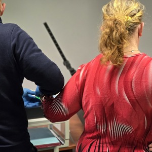 zdjęcie przedstawia policjanta wykonującego czynności służbowe z zatrzymaną kobietą