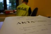 grafika przedstawia akta a w tle policjanta w kamizelce