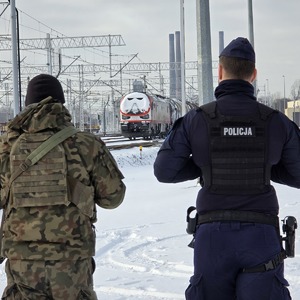 zdjęcie przedstawia policjanta i żołnierza podczas patrolu na torowisku