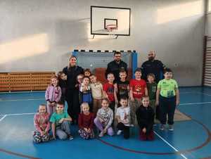 zdjęcie przedstawia policjantów i strażnika miejskiego na spotkaniu z pierwszoklasistami