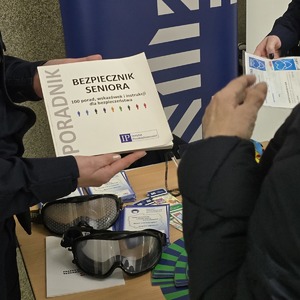 zdjęcie przedstawia policjantkę wręczającą ulotkę