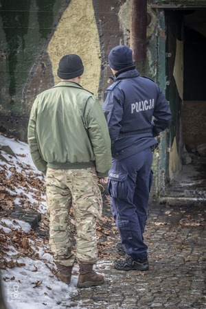 zdjęcie przedstawia policjanta rozmawiającego z uczestnikiem wydarzenia