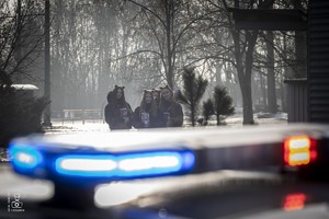 zdjęcie przedstawia zbliżenie na sygnał policyjny a w tle wolontariusze WOŚP