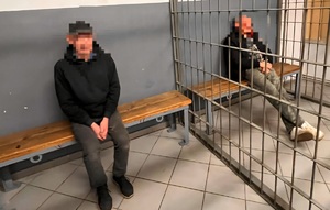 zdjęcie przedstawia dwóch mężczyzn za kratami