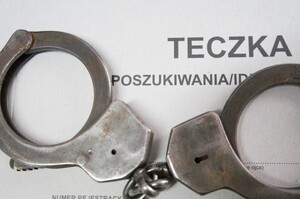 zdjęcie przedstawia kajdanki na teczce z napisem poszukiwania