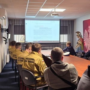 zdjęcie przedstawia policjanta szkolącego strażaków