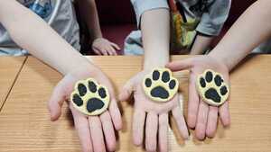 zdjęcie przedstawia odbite psie łapki na rękach uczniów