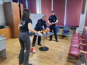 zdjęcie przedstawia mundurowych i pracownika schroniska podczas prelekcji w szkole