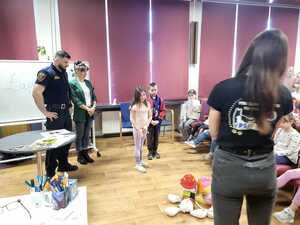 zdjęcie przedstawia mundurowych i pracownika schroniska podczas prelekcji w szkole