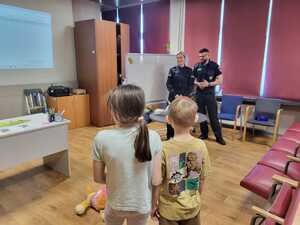 zdjęcie przedstawia mundurowych i pracownika schroniska podczas prelekcji w szkole