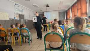 zdjęcie przedstawia policjantkę rozmawiającą z dziećmi