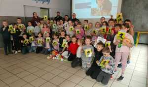 zdjęcie grupowe policjantki, strażnika miejskiego i dzieci ze szkoły