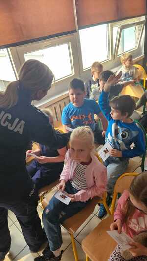 zdjęcie przedstawia policjantkę rozdającą broszury informacyjne