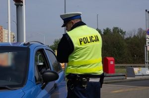 zdjęcie przedstawia policjanta ruchu drogowego rozmawiającego z obywatelem