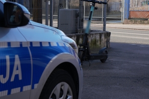 zdjęcie przedstawia radiowóz i w tle hulajnoga elektryczna