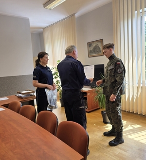 zdjęcie przedstawia komendanta i panią komendant składających gratulacje
