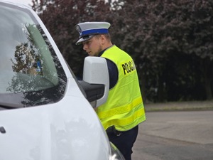 zdjęcie przedstawia policjanta podczas kontroli drogowej