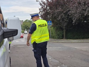 zdjęcie przedstawia policjanta podczas kontroli drogowej