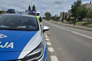 zdjęcie przedstawia radiowóz i policjanta