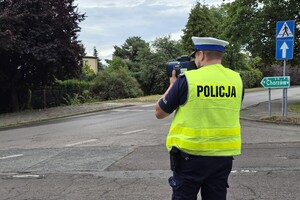 zdjęcie przedstawia policjanta mierzącego prędkość