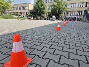 zdjęcia policjant umundurowany i dzieci podczas zdawania na kartę rowerową