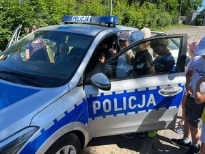 zdjęcie przedstawia dzieci oglądające policyjny radiowóz