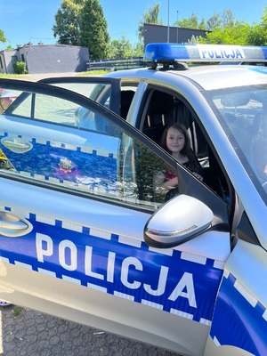 zdjęcie przedstawia dzieci oglądające policyjny radiowóz