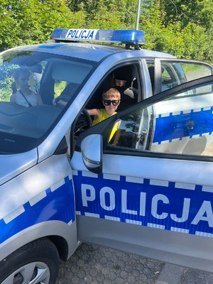 zdjęcie przedstawia dzieci oglądające policyjny radiowóz