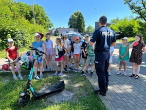 zdjęcie przedstawia policjanta rozmawiającego z dziećmi