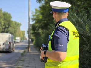 zdjęcie przedstawia policjanta mierzącego prędkość
