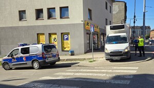 zdjęcie przedstawia straż miejską i nieprawidłowo zaparkowany pojazd