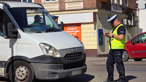 zdjęcie przedstawia policjanta sporządzającego dokumentację