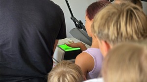 zdjęcie przedstawia dzieci pobierające odciski palców u technika
