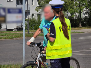 zdjęcie przedstawia policjantkę trzymającą urządzenie do badania trzeźwości rozmawiającą z rowerzystą