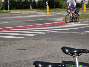 zdjęcie przedstawia przejeżdżającego przez ulicę rowerzystę