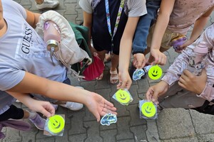zdjęcie przedstawia uczniów trzymających w rękach opaski odblaskowe
