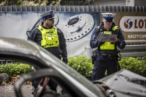 zdjęcie przedstawia policjantów wykonujących oględziny miejsca wypadku
