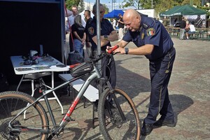 zdjęcie przedstawia strażnika miejskiego znakującego rowery