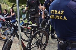 zdjęcie przedstawia strażnika miejskiego znakującego rowery