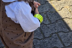 zdjęcie przedstawia dziecko z założona opaską odblaskową